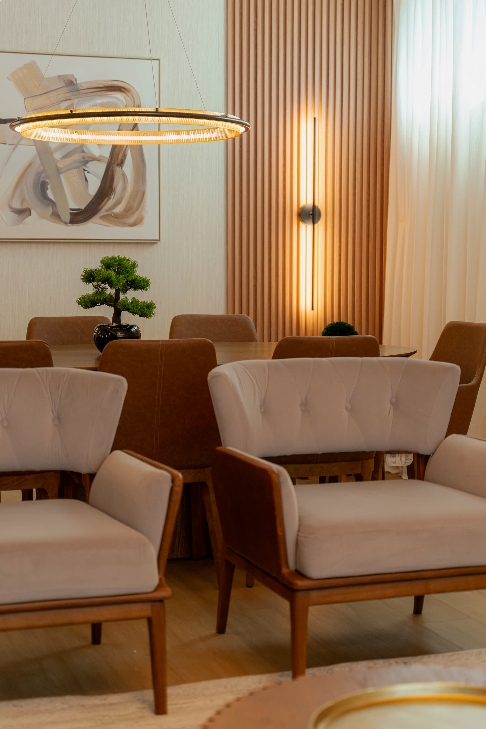 Warm apartment dining area with fluted wood paneling and sculptural pendant light